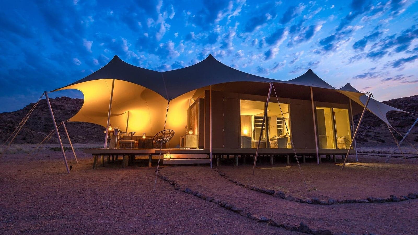 Een tentsuite verlicht bij schemering bij Hoanib Skeleton Coast Camp