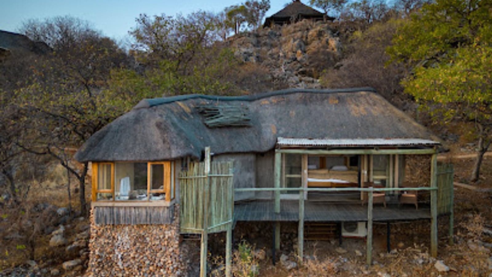 Thatched chalet built into a rocky outcrop at Ongava Lodge, Etosha
